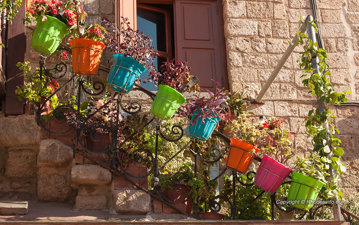 Street in medieval town of Rhodes flowers on ballustrade
